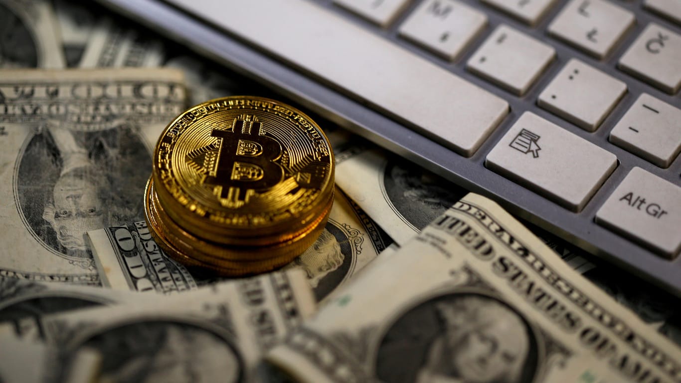 Physische Bitcoin-Münzen liegen auf Dollar-Noten