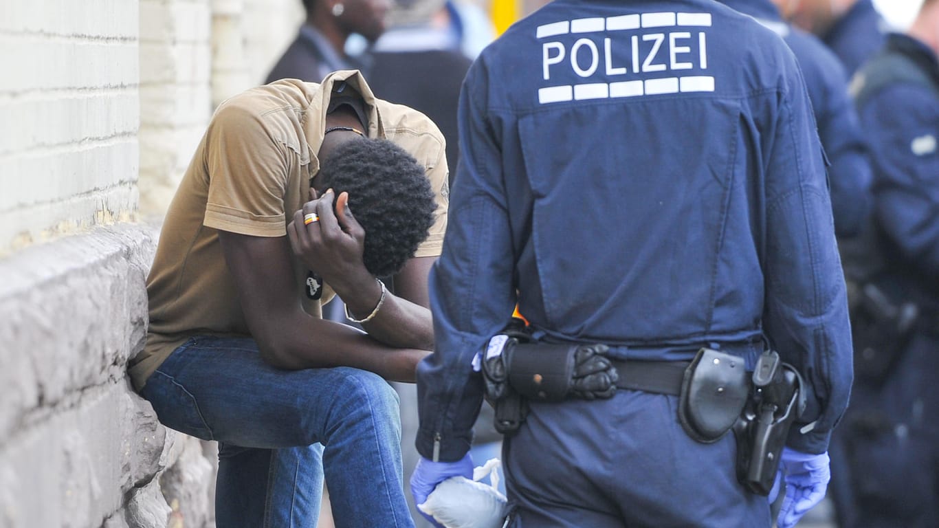 Ein Polizist überwacht in Mannheim vor der Landeserstaufnahmestelle für Flüchtlinge einen Verdächtigen: Trotz des Niedergangs des IS ist das Radikalisierungsrisiko unter Flüchtlingen in Deutschland weiter