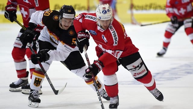 DEB-Spieler Patrick Hager (lI im Zweikampf um den Puck gegen den Schweizer Simon Bodenmann. DEB-Spieler Patrick Hager (lI im Zweikampf um den Puck gegen den Schweizer Simon Bodenmann.