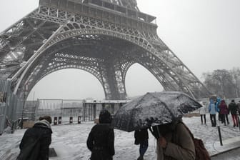 Fußgänger vor dem Pariser Eiffelturm: Das Wahrzeichen muss aufgrund des Schneefalls für Besucher bis auf weiteres geschlossen bleiben.