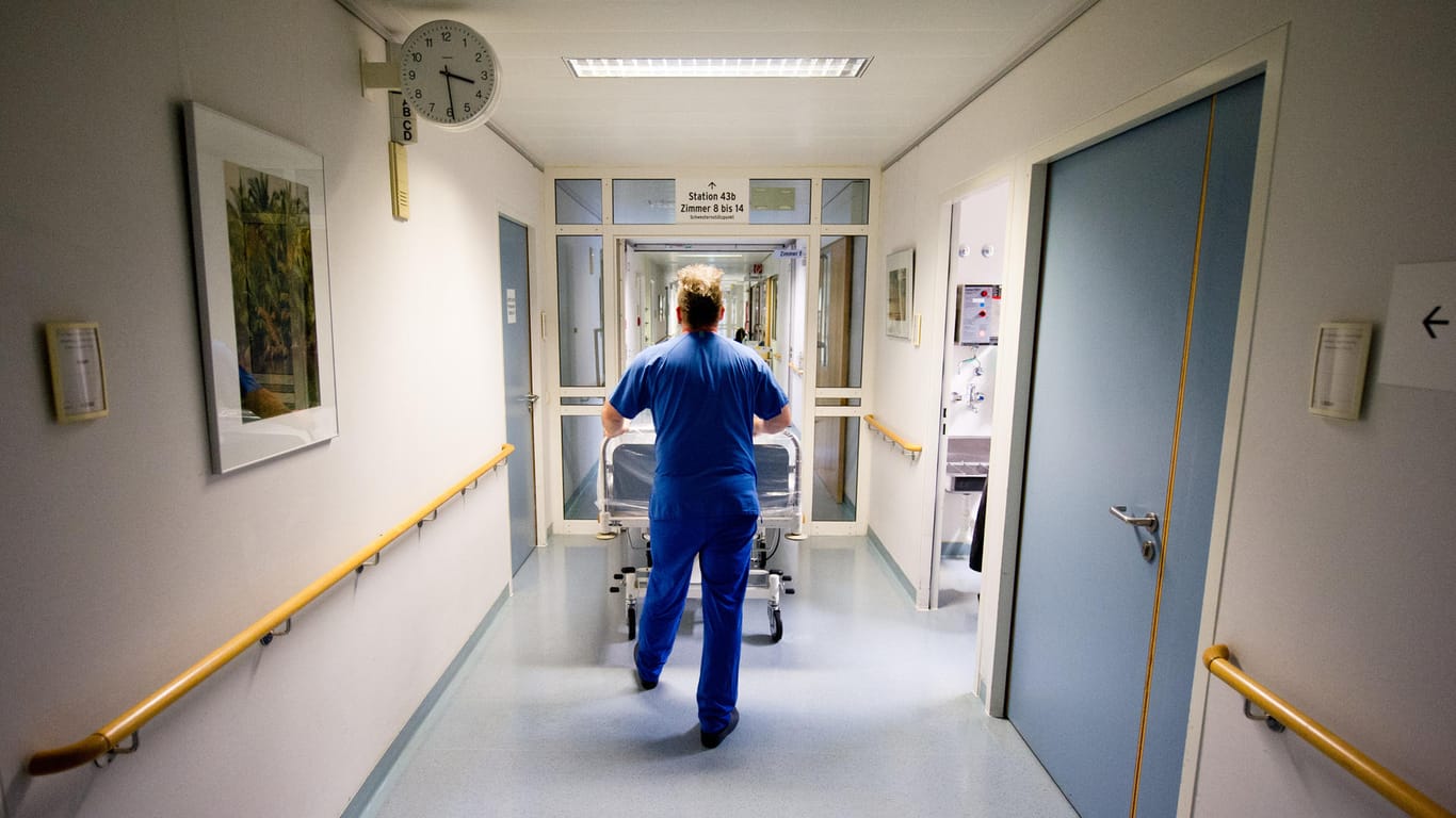 Krankenpfleger mit Bett: Die Zahl der Krankenbetten ist in Deutschland seit 1991 um 16 Prozent gesunken.