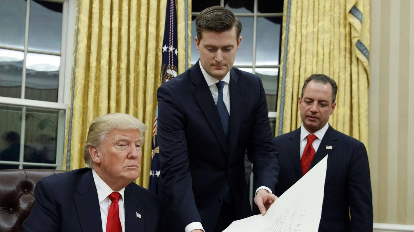 Rob Porter (Mitte) legt Donald Trump ein Schriftstück vor, Reince Priebus (re.), der damalige Stabschef im Weißen Haus, schaut zu. Porter ist nach Vorwürfen seiner beiden Ex-Frauen zurückgetreten.