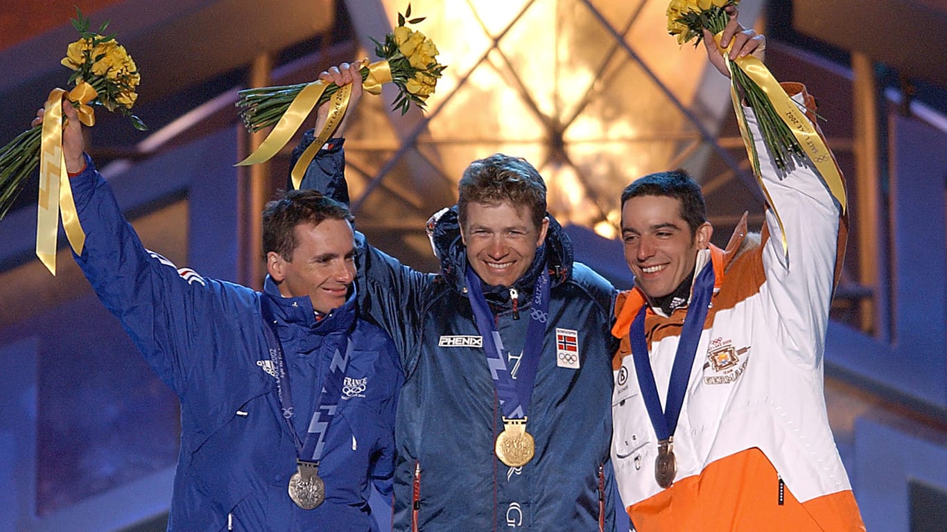 Ole Einar Bjørndalen feiert eine Goldmedaille in Salt Lake City 2002. Links Silbermedaillengewinner Raphael Poiree, rechts Ricco Gross aus Deutschland, der Bronze gewann.