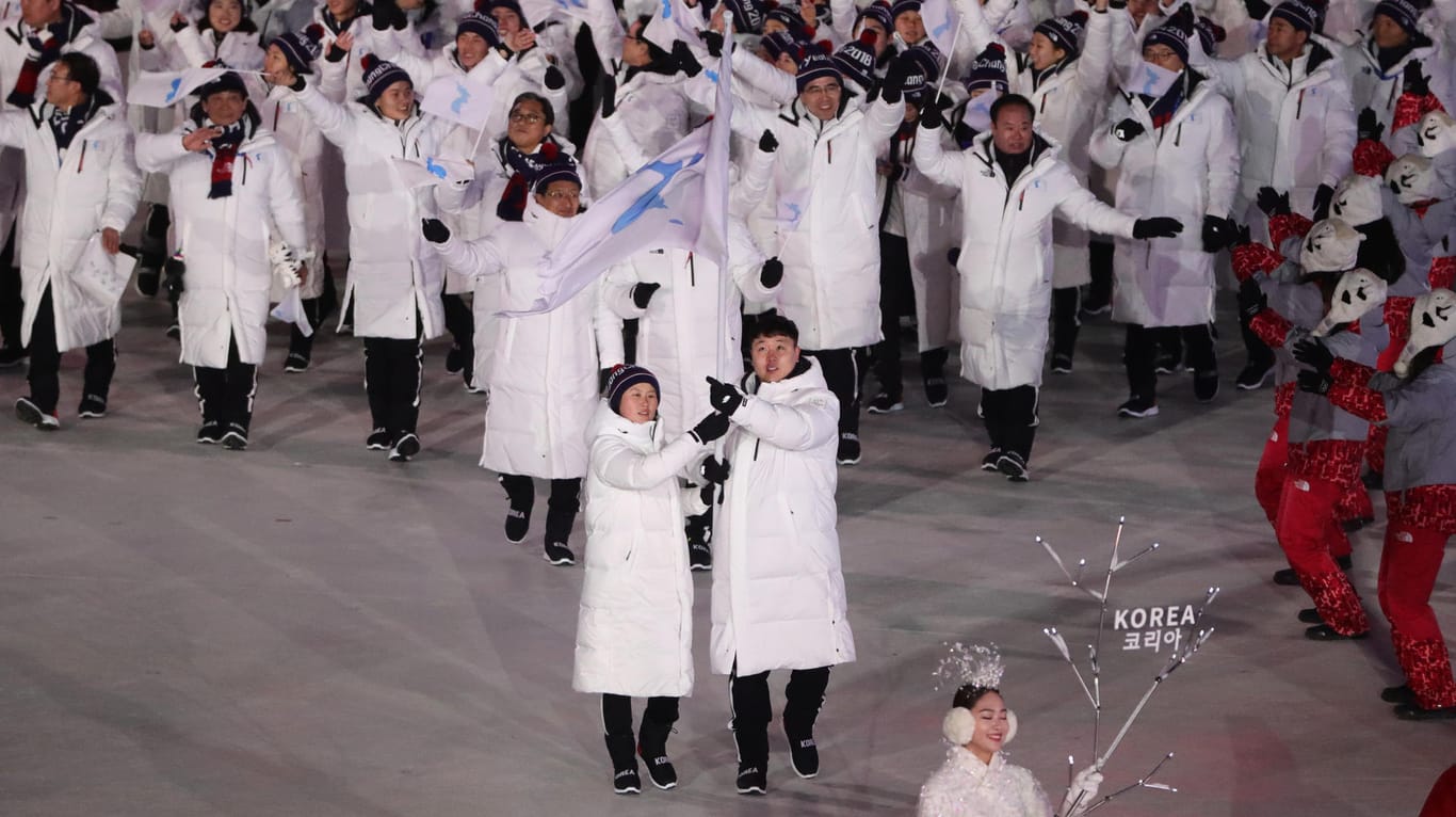 Der südkoreanische Bobfahrer Won Yun Jong und die nordkoreanische Eishockeyspielerin Hwang Chung Gum führen das gemeinsame Team ins Stadion.