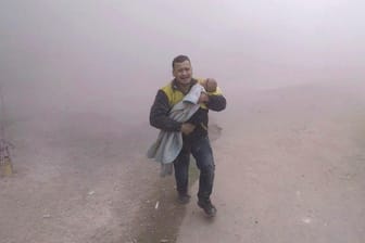 Luftangriffe in Ost-Ghuta: Das Bild soll einen Helfer der Organisation "Weißhelme" mit seinem verletzten Sohn auf dem Arm zeigen.