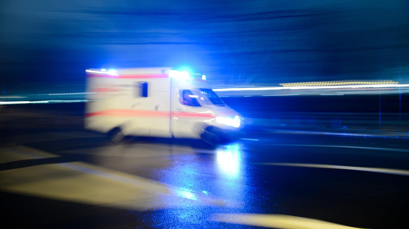 Ein Rettungswagen mit Blaulicht fährt durch eine Straße: Nach einem Grillabend im Keller brachten Rettungskräfte sieben Schwerverletzte mit Kohlenmonoxid-Vergiftungen in Kliniken. (Archivbild)