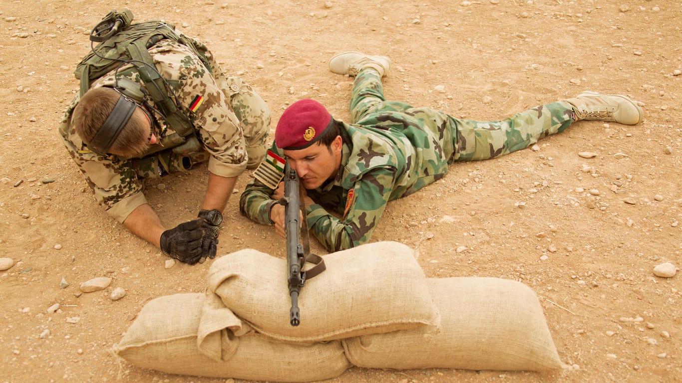 Bundeswehr im Irak: Ein deutscher Soldat gibt einem kurdischen Peschmerga nahe Erbil Schießtraining. Aufnahme aus dem Jahr 2014.