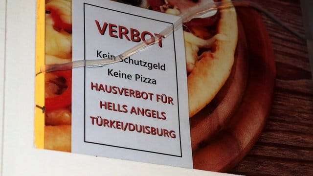 Ein Schild ist auf der Scheibe einer Pizzeria zu sehen.