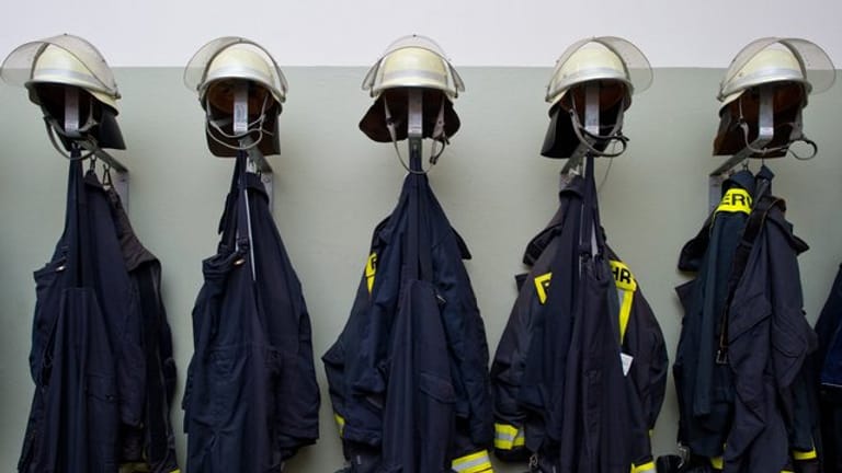 Feuerwehruniformen hängen in einem Gebäude einer Freiwilligen Feuerwehr (Symbolfoto): Gegen mehrere Feuerwehrleute wird wegen eines Hackerangriffs ermittelt.