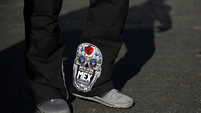 Mexikos Rennanzüge: Weiße Totenköpfe auf schwarzem Grund verziert mit roten Blumen. Mexikos Rennanzüge: Weiße Totenköpfe auf schwarzem Grund verziert mit roten Blumen.