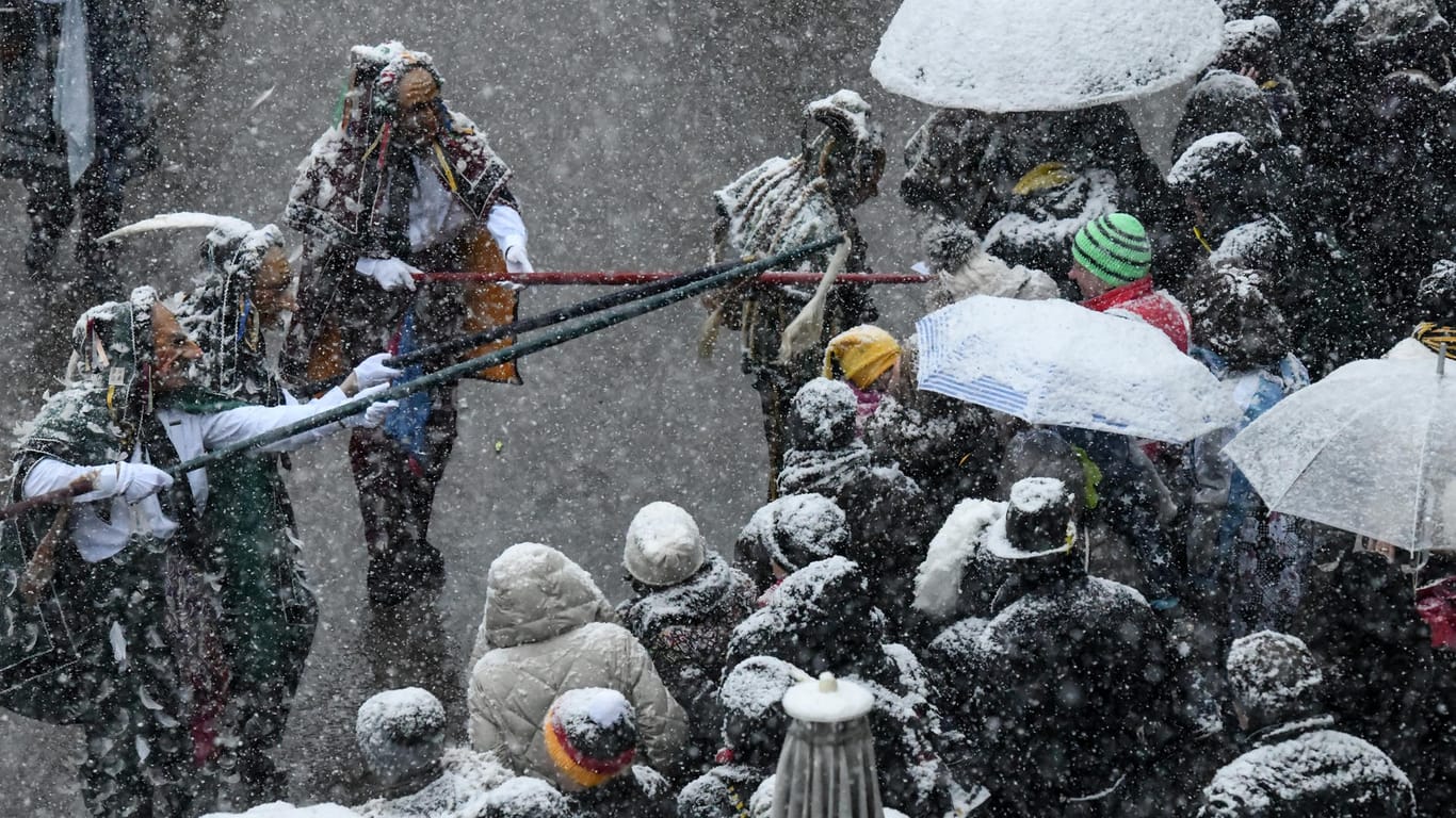 Beim Narrensprung in Baden-Württemberg hatten die Zuschauer bereits mit Schneeschauern zu kämpfen: Für die Rosenmontagszüge am Rhein ist nicht viel besseres Wetter angesagt.
