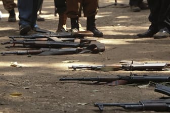 Gewehre ehemaliger Kindersoldaten aus dem Südsudan bei einer Feier anlässlich ihrer Freilassung auf dem Boden.