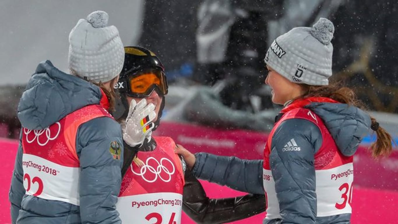 Katharina Althaus (M), Ramona Straub (l) und Carina Vogt wünschen sich weitere Wettkämpfe bei Winterspielen.