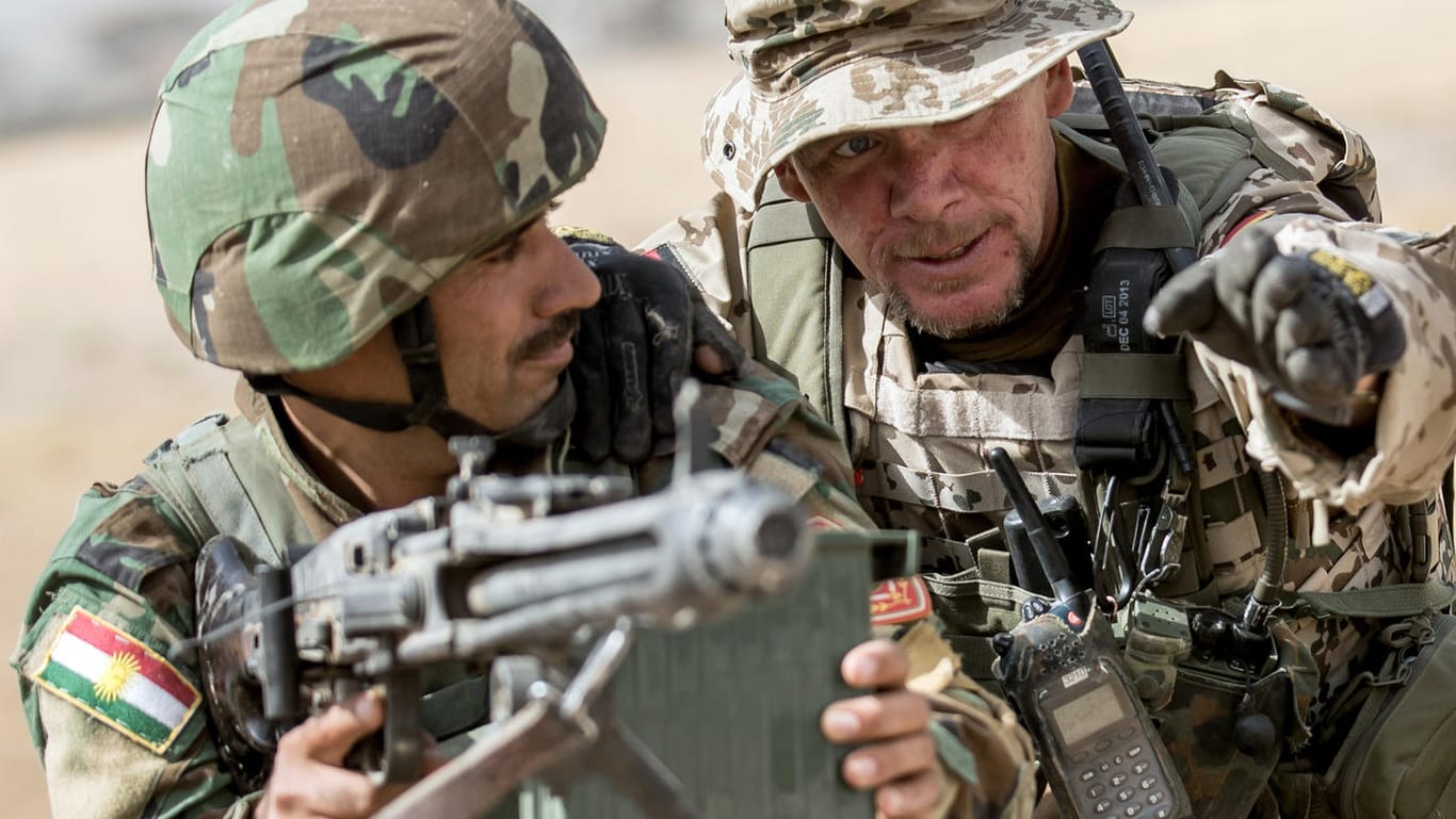 Ein Bundeswehrsoldat weist einen kurdischen Peschmerga-Kämpfer ein: Derzeit sind im Irak nur etwa 20 Nato-Ausbilder aktiv.