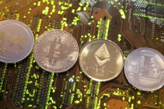 Darstellungen der Kryptowährungen Ripple, Bitcoin, Ethereum und Litecoin