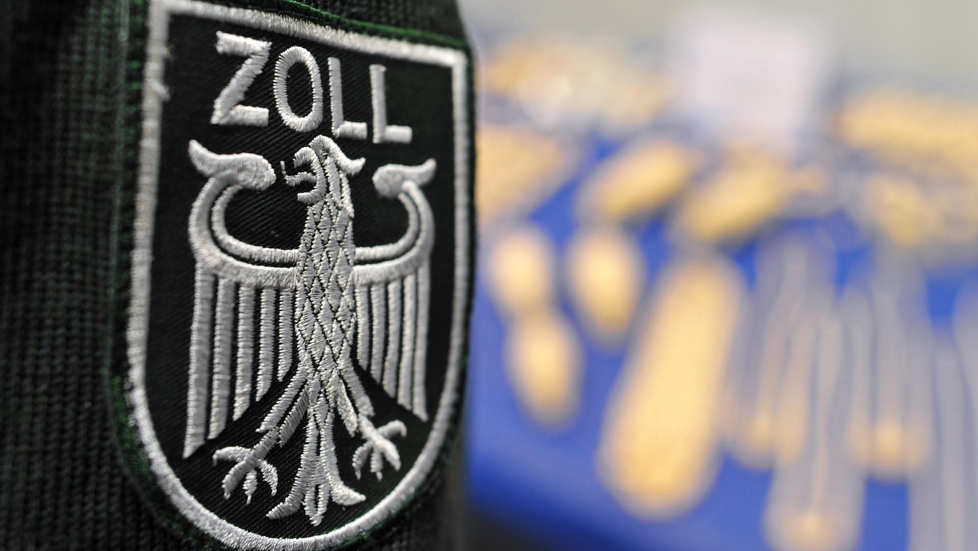Zollwappen an Uniform: Zoll findet bei Kontrolle über 100.000 Euro Bargeld in einer Karaokemaschine. Zollwappen an Uniform: Zoll findet bei Kontrolle über 100.000 Euro Bargeld in einer Karaokemaschine.