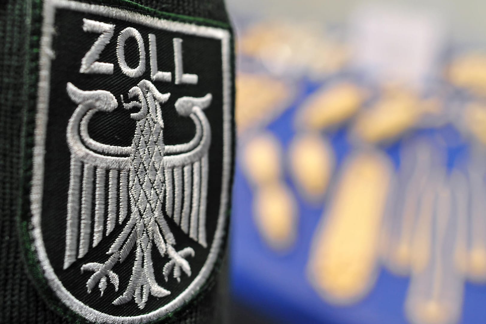 Zollwappen an Uniform: Zoll findet bei Kontrolle über 100.000 Euro Bargeld in einer Karaokemaschine.