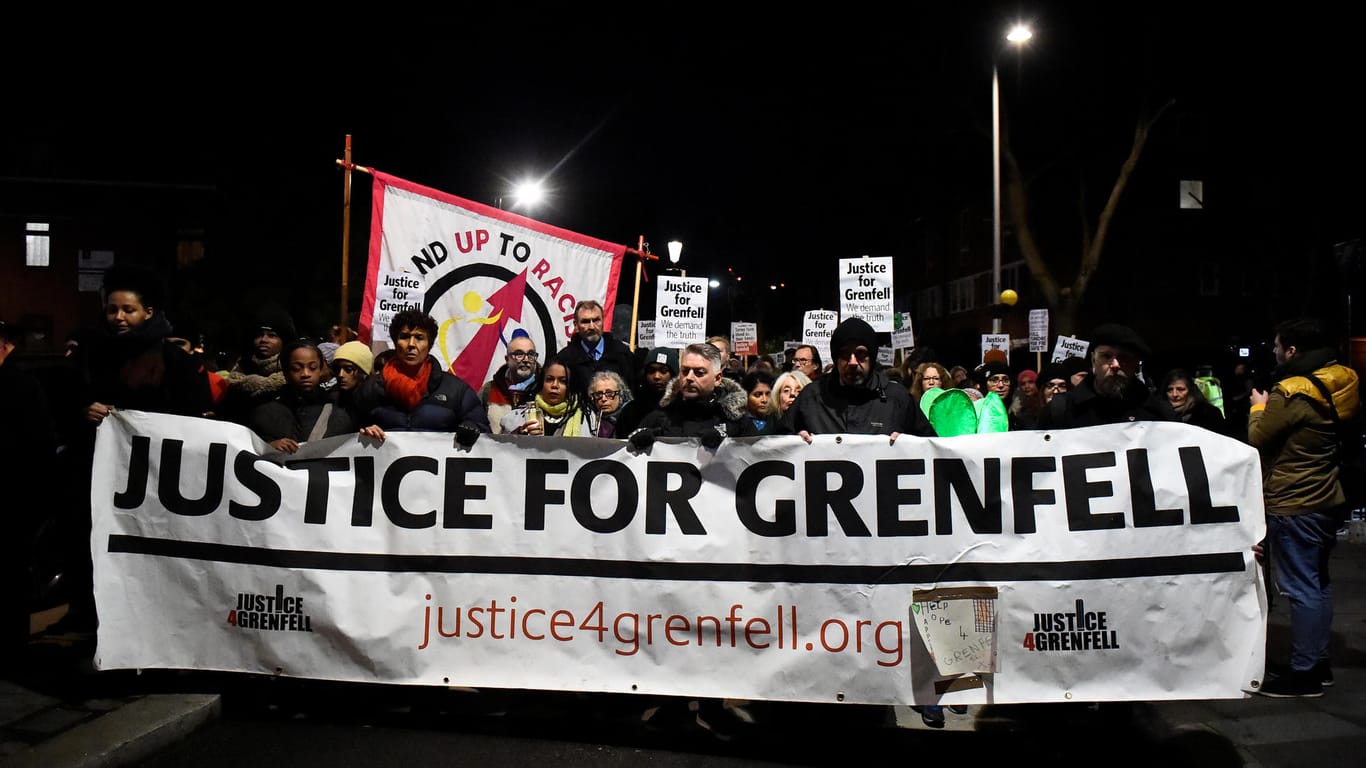 People take part in a silent candlelit march to mark the six month anniversary of the Grenfell Tower fire in London
