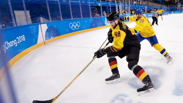 Frank Hördler (v) nimmt den Puck vor Schwedens Joel Lundqvist an.