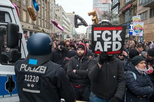 Polizisten blockieren beim "Frauenmarsch" Gegendemonstranten am Checkpoint Charlie in Berlin.
