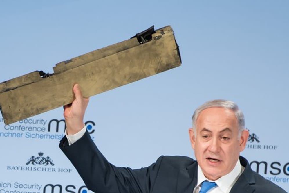 Benjamin Netanjahu, Ministerpräsident von Israel, spricht hält ein Stück einer abgeschossenen Drohne hoch.