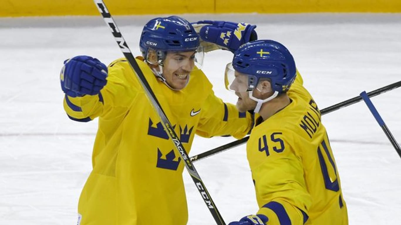Die Schweden Pär Lindholm (l) und Oscar Möller feienr ein Tor gegen Finnland.