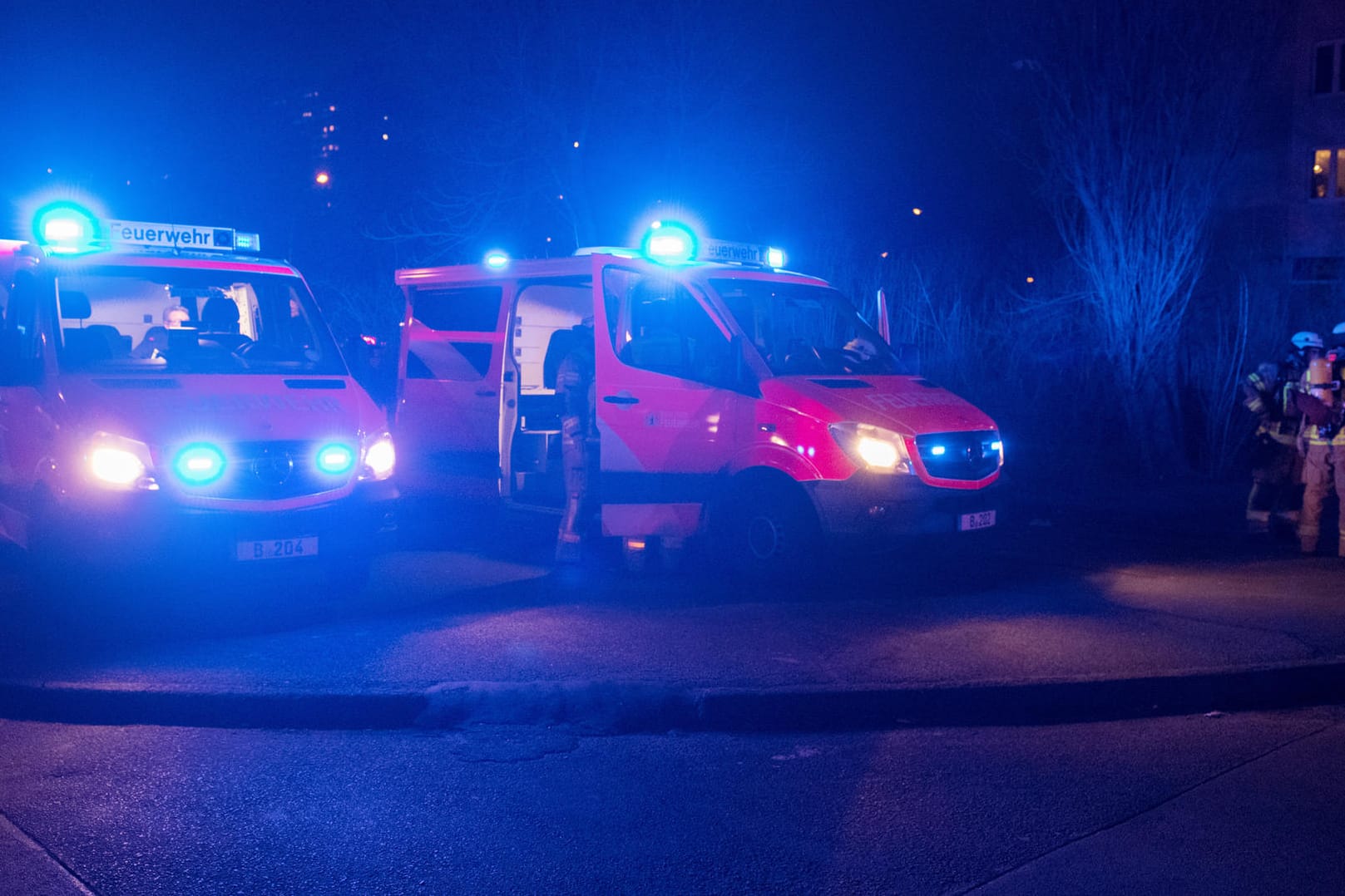 Einsatzfahrzeuge der Feuerwehr stehen am Sonntag (18.02.18) mit eingeschaltetem Blaulicht an einem Hochhaus an der Landsberger Allee in Berlin: Dort brannte es in den vergangenen fünf Tagen insgesamt vier Mal.