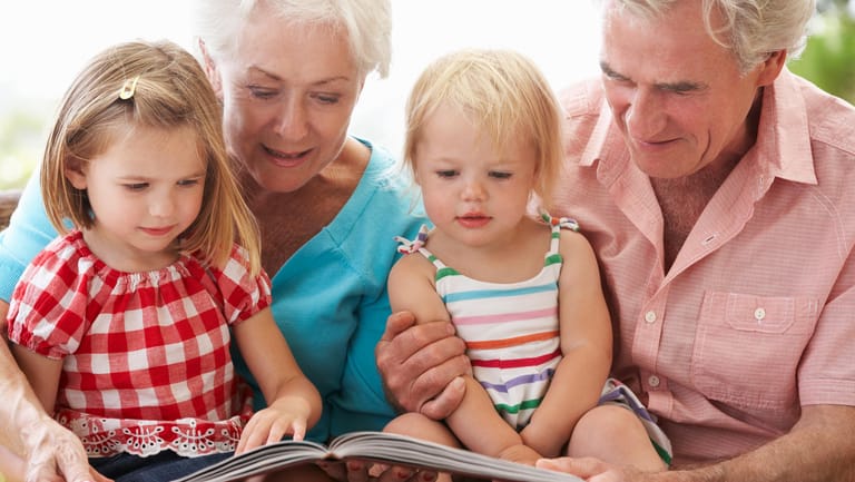Großeltern lesen ihren Enkeln etwas vor: Gemeinsam Zeit zu verbringen macht Spaß.
