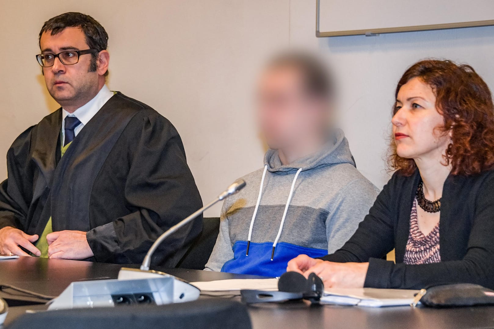 Der Angeklagte wartet neben seinem Anwalt und einer Dolmetscherin auf den Beginn der Verhandlung: Das Gericht verurteilte den Mann zu lebenslanger Haft.
