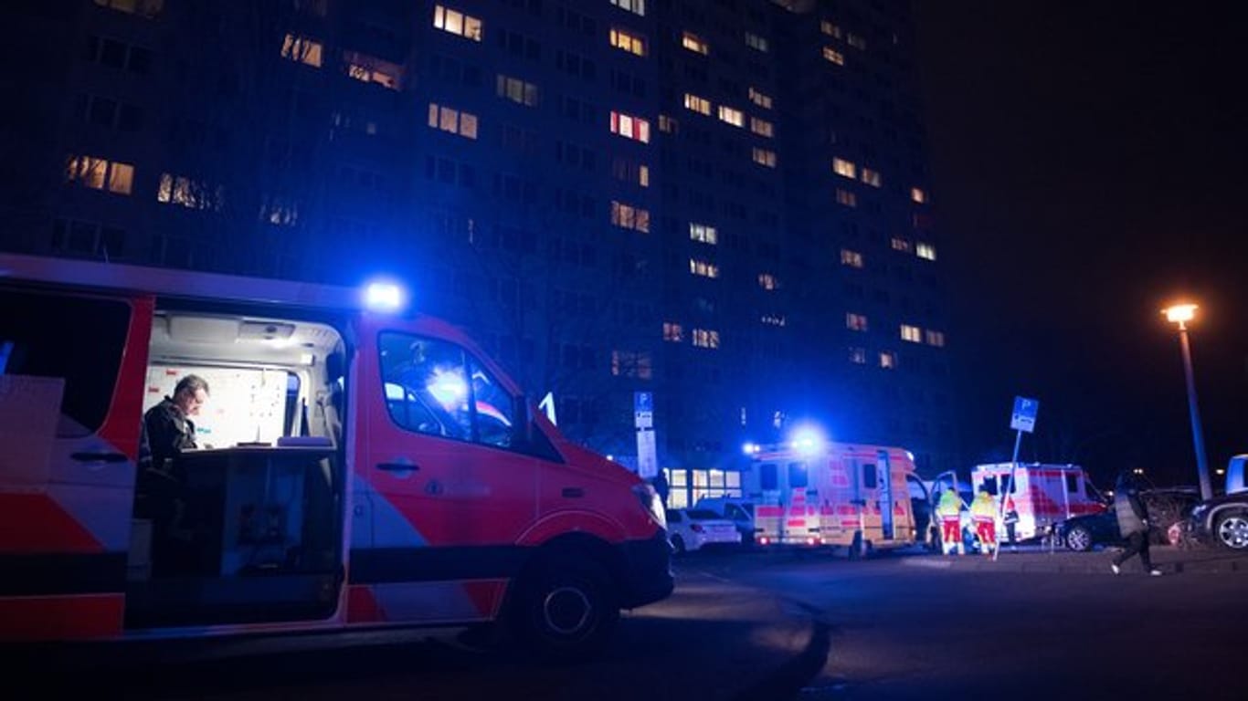 Ein Einsatzfahrzeug der Feuerwehr und ein Rettungswagen stehen an einem Hochhaus in Berlin.