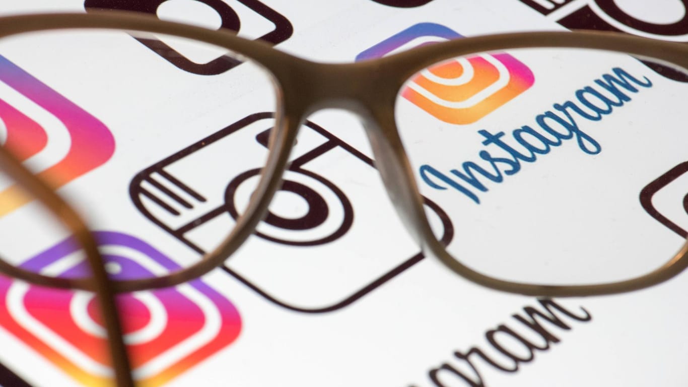Eine Lesebrille liegt auf einem Bildschirm mit dem Instagram-Logo