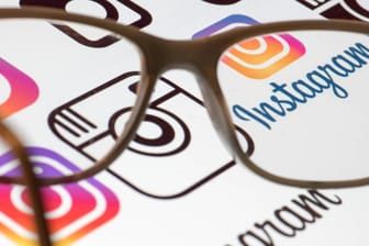 Eine Lesebrille liegt auf einem Bildschirm mit dem Instagram-Logo