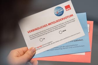 Ein SPD-Mitglied schaut sich seine Unterlagen für das SPD-Mitgliedervotum zur Bildung einer Großen Koalition mit der Union an.