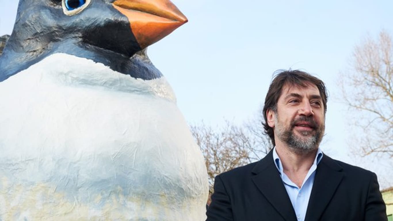 Oscar-Preisträger Javier Bardem neben einem übergroßen Pinguin.