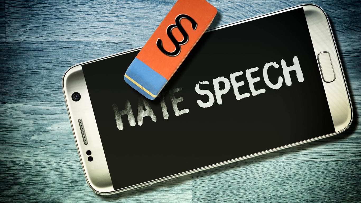 Schriftzug Hate Speech auf dem Handydisplay wird wegradiert Symbolfoto Netzwerkdurchsetzungsgesetz