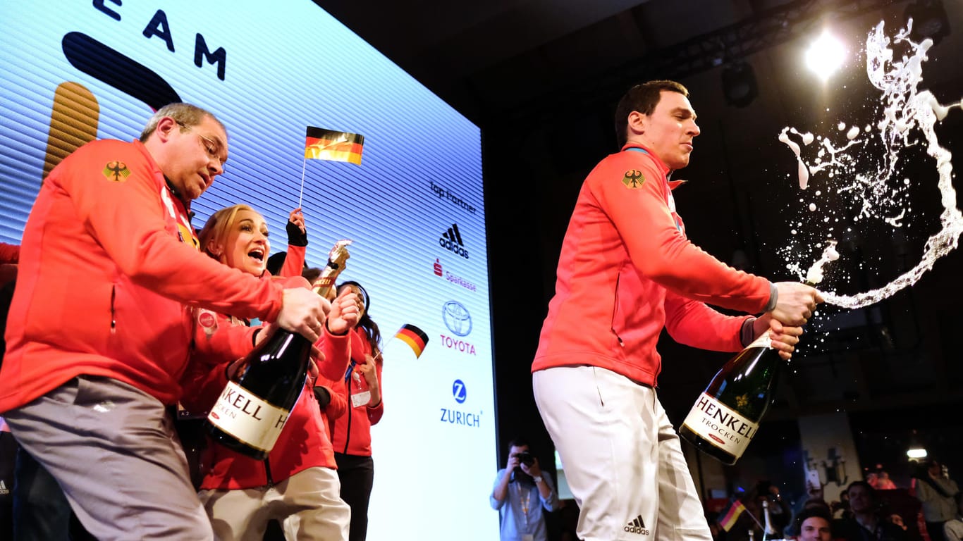Tradition im Deutschen Haus: Die Medaillengewinner (wie hier, Eiskunstläufer Bruno Massot) werden auf der Bühne empfangen und köpfen eine Flasche Champagner.