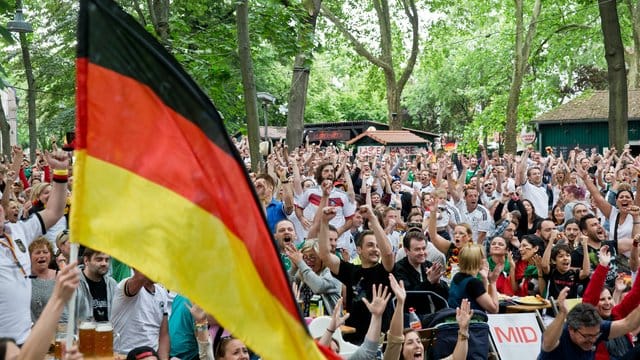 Fans jubeln während der Übertragung eines WM-Spiels in einem Biergarten.