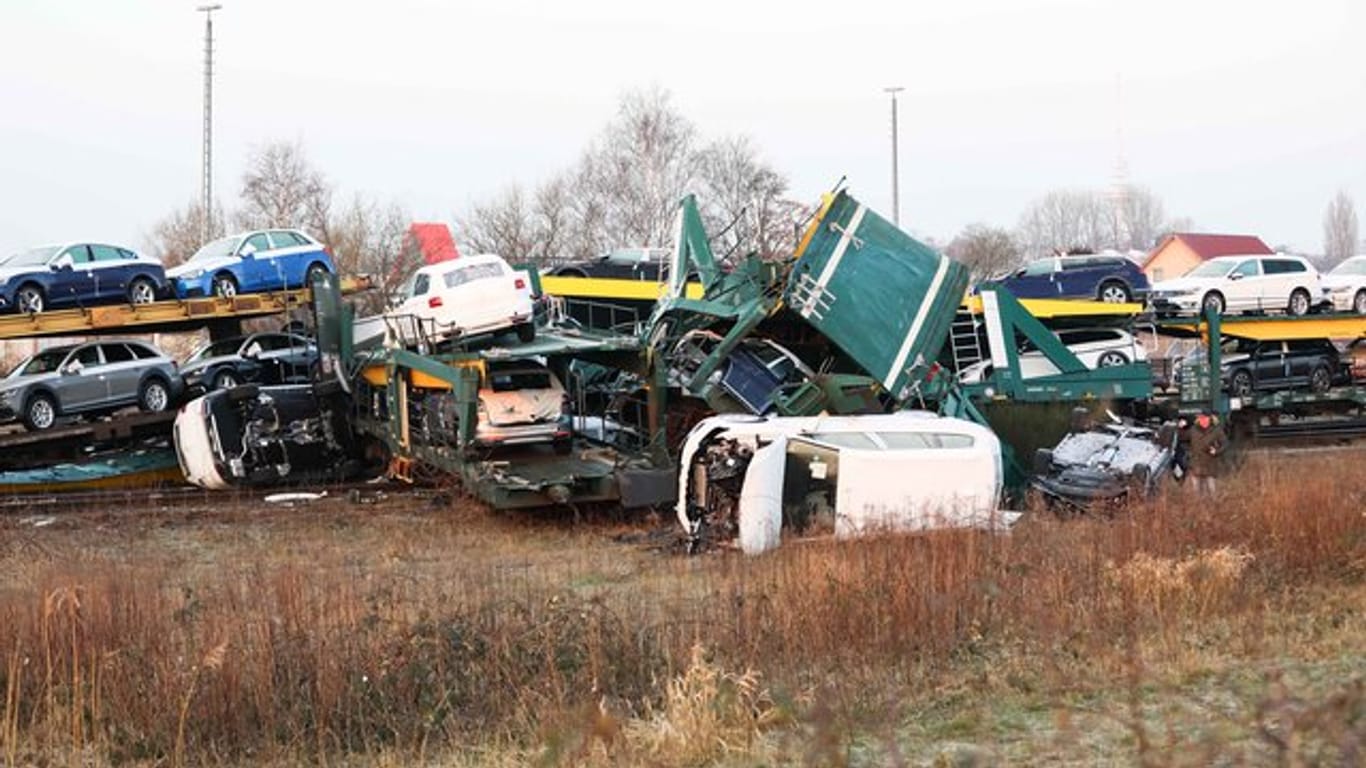 Heruntergefallene Fahrzeuge liegen neben einem entgleisten Waggon eines Autotransportzugs im Güterbahnhof in Cuxhaven.