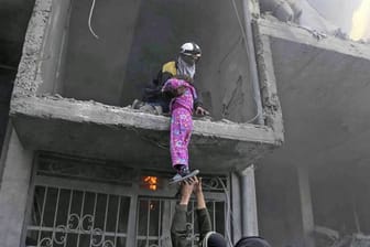 Mitglieder des Syrischen Zivilschutzes retten während eines Luftangriffs ein Mädchen aus einem zerstörten Gebäude in Ost-Ghuta.