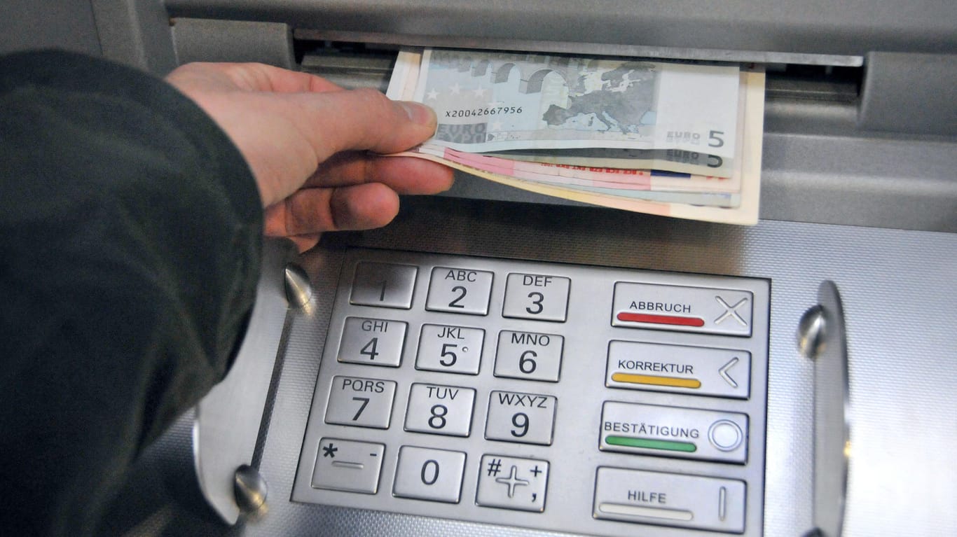 Eine Hand entnimmt dem Geldschlitz eines Bankautomaten die gewünschten Banknoten: Die Spur zu der vermissten 14-Jährigen und ihrem Betreuer führt nach Hamburg. Eine der beiden Personen soll hier versucht haben, Geld abzuheben. (Symbolbild)