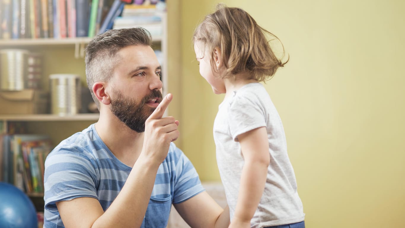 Ein Vater erklärt seinem Kind etwas mit erhobenem Zeigefinger