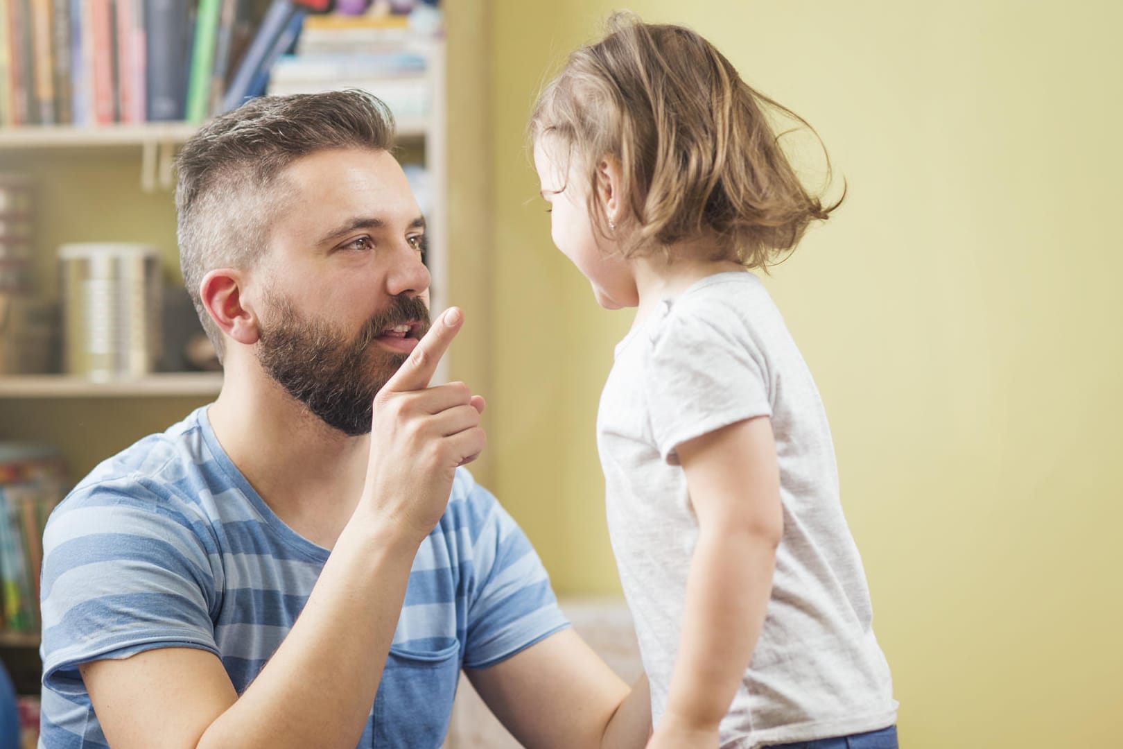 Ein Vater erklärt seinem Kind etwas mit erhobenem Zeigefinger