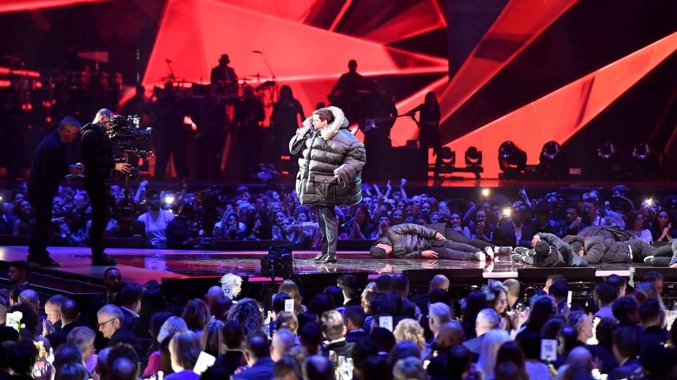 Moderator Jack Whitehall: Er steht in einer überdimensional großen Winterjacke bei den Brit Awards 2018 auf der Bühne.