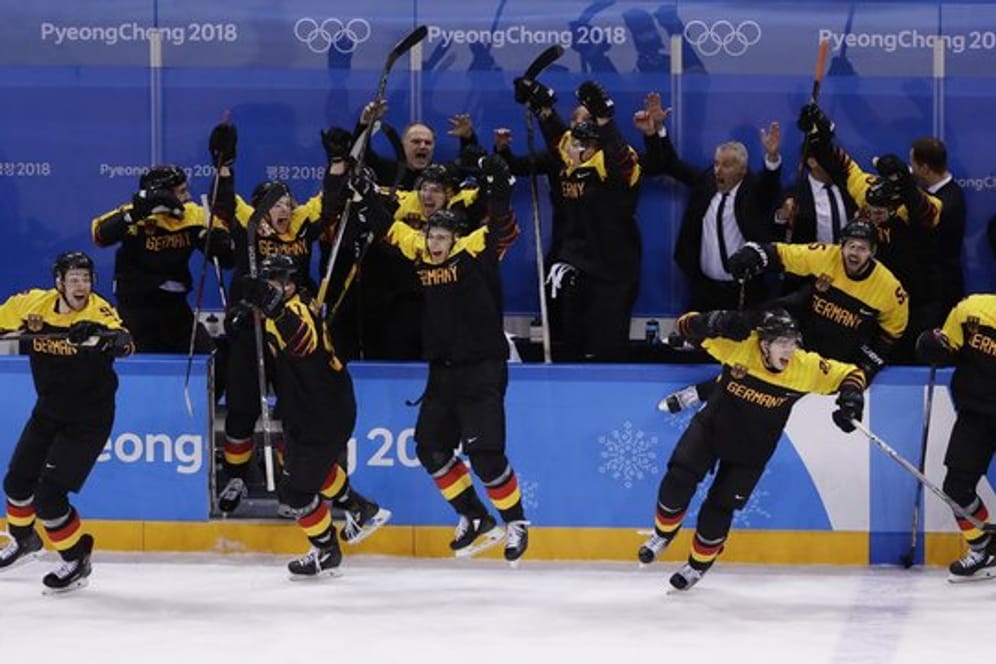 Die deutschen Eishockey-Spieler stürmen nach dem Sieg gegen Schweden auf das Eis.