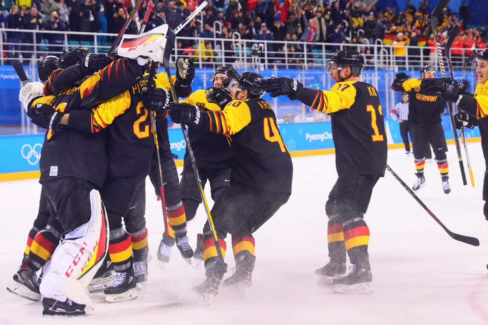 Das deutsche Eishockeyteam bejubelt den Viertelfinalsieg gegen Schweden.