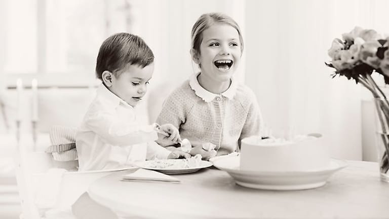 Klein-Oscar nascht Kuchen, während sich seine große Schwester über irgendetwas riesig freut.