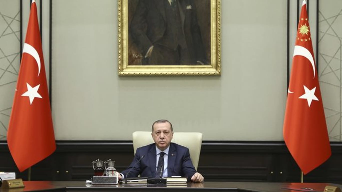 Recep Tayyip Erdogan, Staatspräsident der Türkei, sitzt vor einem Bild von Atatürk, dem Begründer der Republik Türkei.
