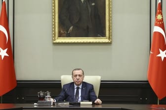 Recep Tayyip Erdogan, Staatspräsident der Türkei, sitzt vor einem Bild von Atatürk, dem Begründer der Republik Türkei.