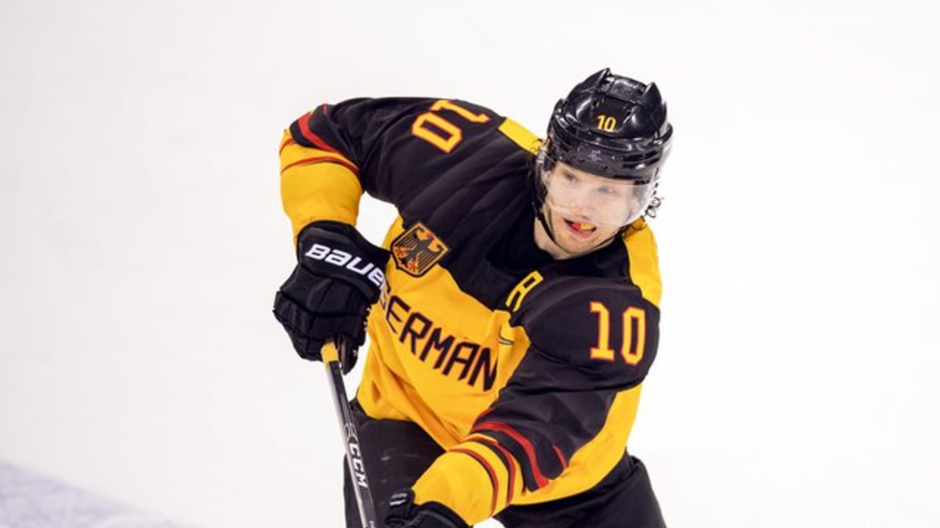 Eishockey-Nationalspieler Christian Ehrhoff (l) trägt bei der Abschlussfeier in Pyeongchang die deutsche Fahne.
