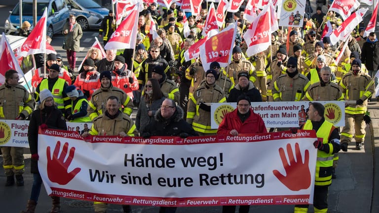 Einsatzkräfte gehen mit Plakaten und Verdi-Fahnen durch Frankfurt: Rettungskräfte demonstrieren in der Banken-Metropole für mehr Respekt und gegen Gewalt bei ihren Einsätzen.